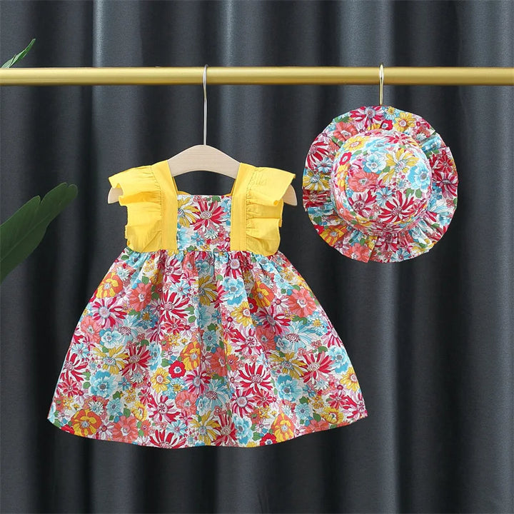 "Luftiges Blumenkleid mit floralem Muster und passendem Hut, ideal für Mädchen an warmen Sommertagen."