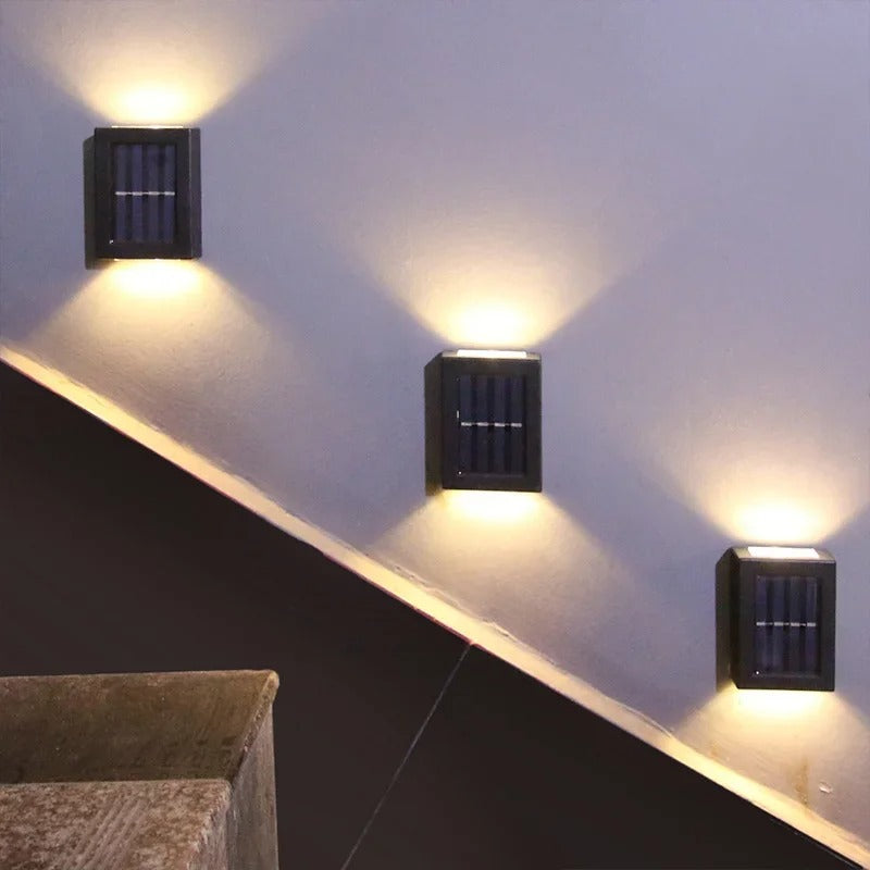 Drei schwarze LED-Solar-Wandleuchten an Treppe, modernes Design, energiesparend.