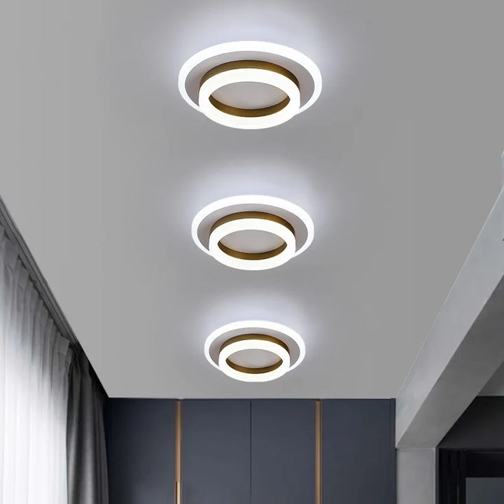 Moderne LED-Deckenleuchte mit minimalistischer, flacher Silhouette und eleganten Metall- und Glaselementen.