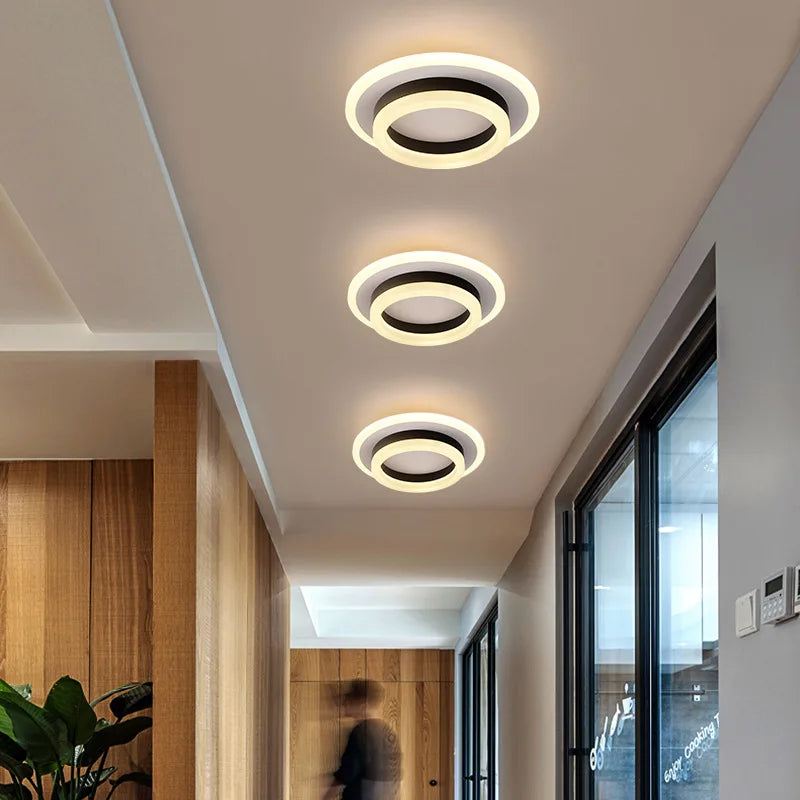 Moderne LED-Deckenleuchte mit minimalistischer, flacher Silhouette und eleganten Metall- und Glaselementen.