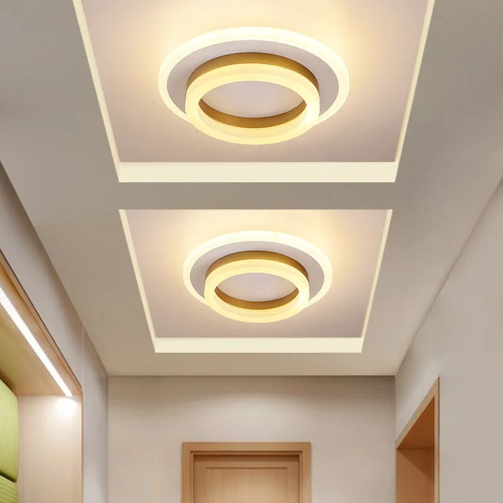 Moderne LED-Deckenleuchte mit minimalistischer, flacher Silhouette und eleganten Metall- und Glaselementen.