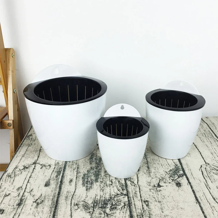 "Moderner, platzsparender Hängepflanztopf mit Selbstbewässerungssystem für optimale Pflanzenpflege drinnen und draußen."