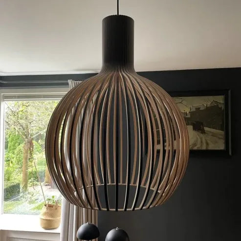 "Nordische Holz-Pendelleuchte in Vogelkäfigform, handgefertigt, stilvolles Design, warmes Licht für moderne Räume."