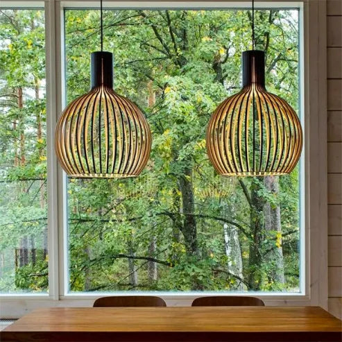 "Nordische Holz-Pendelleuchte in Vogelkäfigform, handgefertigt, stilvolles Design, warmes Licht für moderne Räume."
