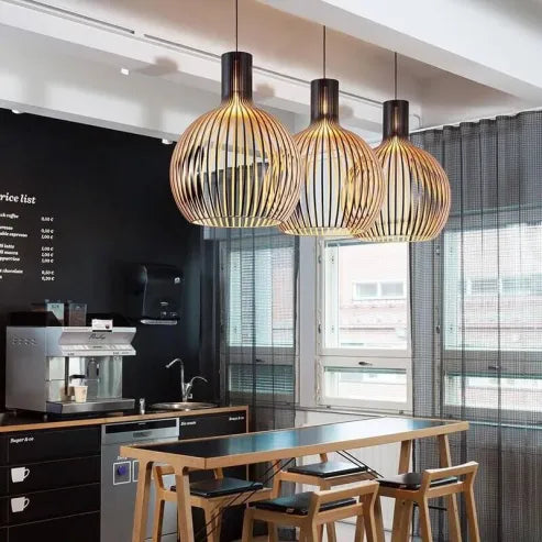 "Nordische Holz-Pendelleuchte in Vogelkäfigform, handgefertigt, stilvolles Design, warmes Licht für moderne Räume."