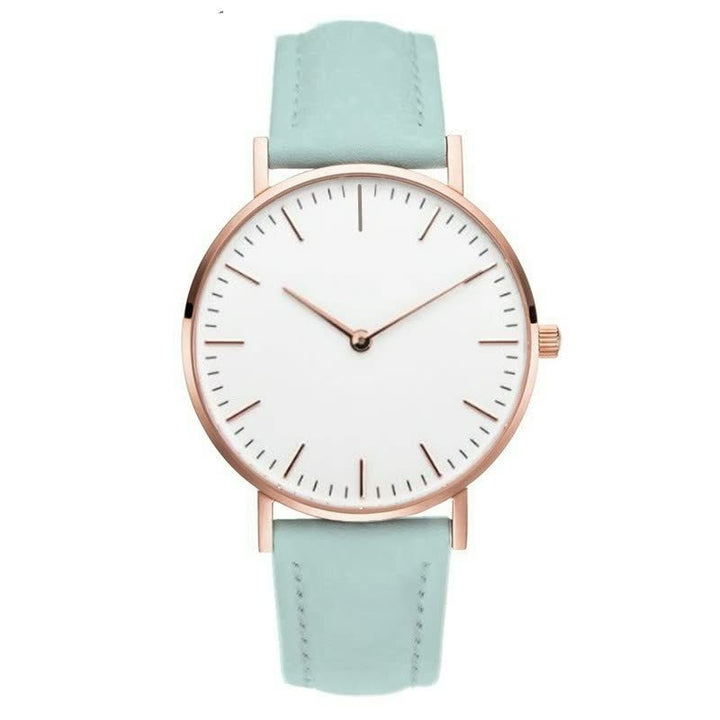 Minimalistische Armbanduhr mit weißem Zifferblatt, roségoldenem Gehäuse und mintgrünem Lederarmband.
