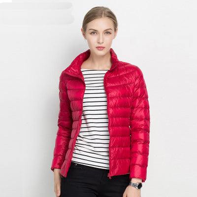 Frau in roter Daunenjacke, gestreiftes Shirt, modische Winterbekleidung, elegant und warm.