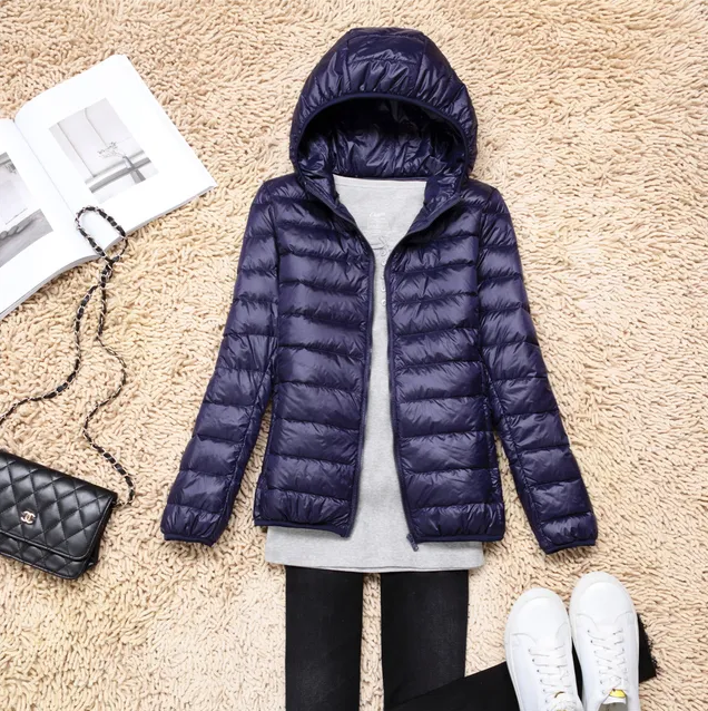 Ultraleichte Daunenjacke für Damen, in Blau, mit Kapuze und verstaubar. Ideal für Outdoor-Abenteuer, wetterfest und stilvoll.