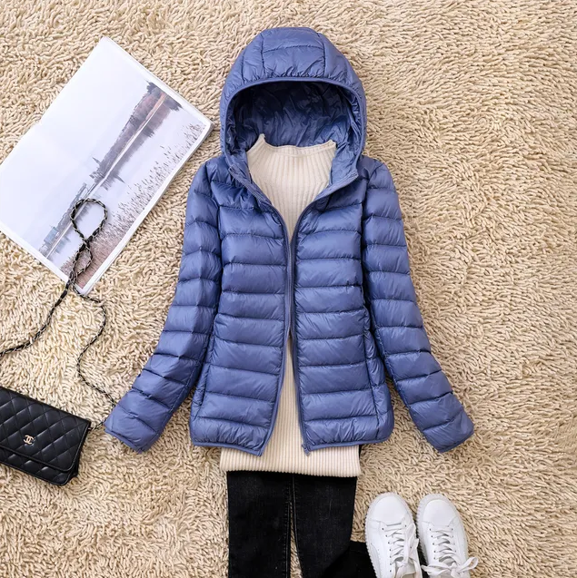 Ultraleichte Daunenjacke für Damen, in Blau, mit Kapuze und verstaubar. Ideal für Outdoor-Abenteuer, wetterfest und stilvoll.
