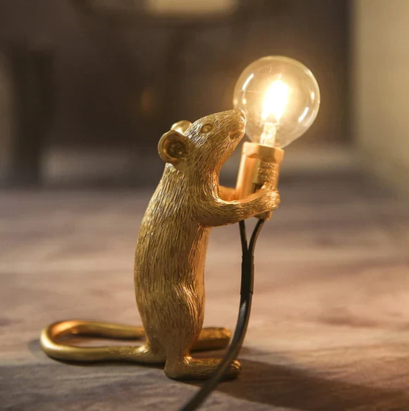 "Weiße Maus Tischleuchte in sitzender Position, strahlt warmes Licht, ideal für stilvolle Wohn- oder Schlafräume."
