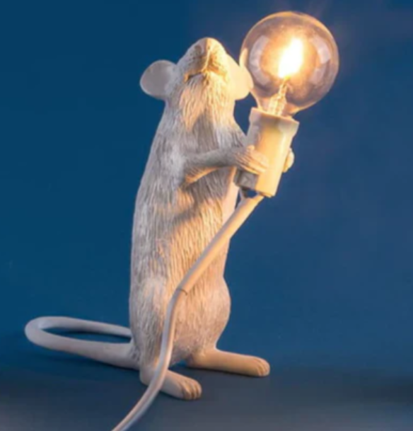 "Weiße Maus Tischleuchte in sitzender Position, strahlt warmes Licht, ideal für stilvolle Wohn- oder Schlafräume."