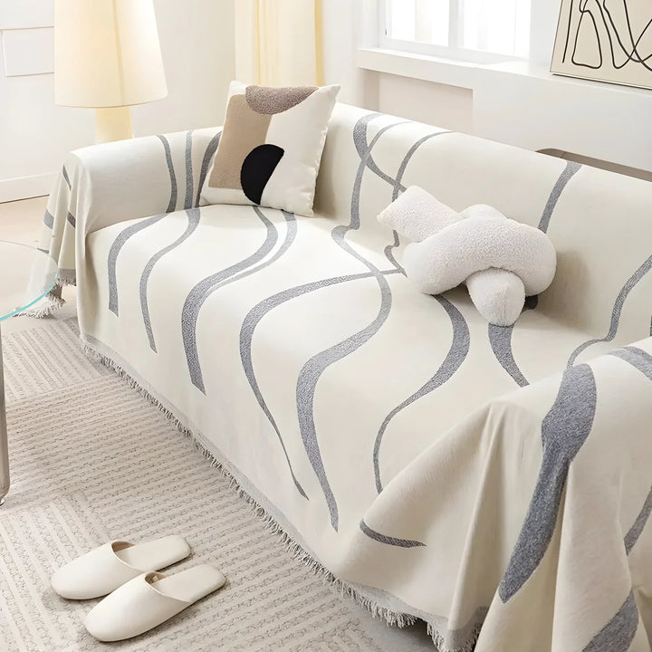 "Wendbarer Sofabezug, modern und schützend, zeigt graues Muster, passend für verschiedene Sofaarten im Wohnzimmer."
